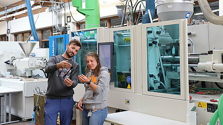 Students in front of an injection moulding machine: lightweight application